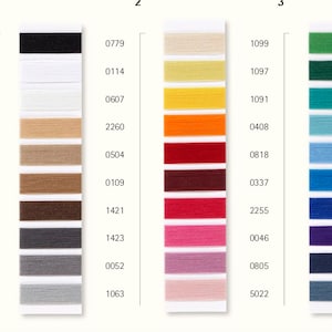 Op de afbeelding: Een kleurenkaart met rijen garenstalen in verschillende kleuren, waaronder zwart, wit, beige, bruin, grijs, geel, oranje, rood, roze, groen, blauw en paars. De kaart is genummerd, bijvoorbeeld 4000, 0779, 1099, 2000, 0114, 1097, 1000, 0607, 1091, 3670, 2260, 0408, 1222, 0504, 0818, 1424, 0109, 0337, 1182, 1421, 2255, 0416, 1423, 0046, 0318, 0052, 0805, 1140, 1063 en 5022.