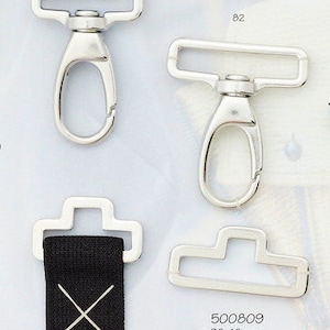 Könnte beinhalten: Zwei silberne Metallschließen mit einem schwarzen Band mit weißen X-Markierungen. Die Schließen sind 30 mm x 40 mm groß und werden in Packungen zu 6 Stück geliefert. Der Text "500809" ist auf dem weißen Hintergrund gedruckt.