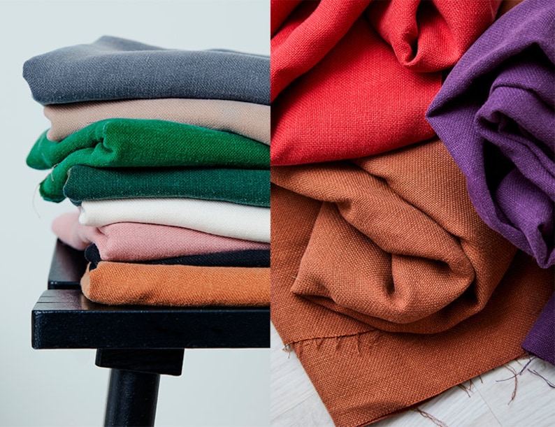 May include: A stack of folded fabric in various colors, including gray, tan, green, white, pink, black, and orange. The fabric is arranged on a black bench. Additional fabric in red, orange, and purple is also displayed.