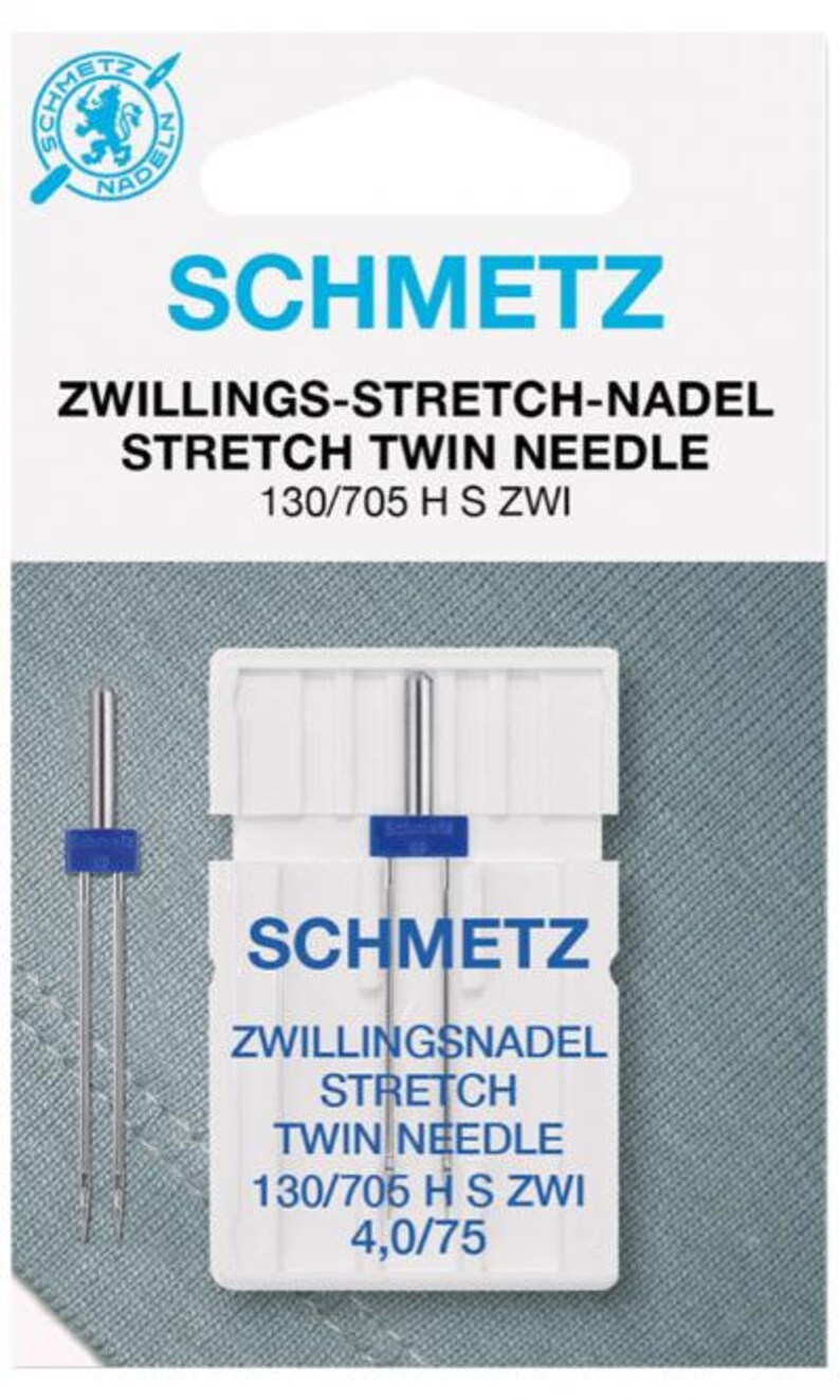 May include: A pack of Schmetz Stretch Twin Needles. The white package has blue accents and text. The needles are silver with blue plastic holders. The text on the package reads "SCHMETZ" and "STRETCH TWIN NEEDLE".