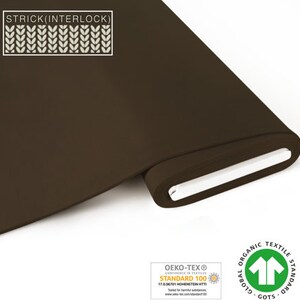 Może przedstawiać: Rolka ciemnobrązowej dzianiny interlock. Tkanina posiada certyfikat Oeko-Tex Standard 100 i Global Organic Textile Standard (GOTS).