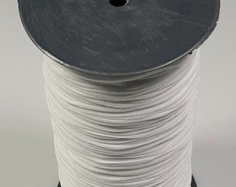 Può includere: Un rotolo di cordoncino elastico bianco avvolto attorno a una bobina di plastica nera. Il cordoncino viene utilizzato per realizzare maschere per il viso.