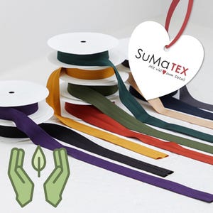 Peut inclure: Bobines de biais colorés dans diverses teintes, dont le vert, le jaune et le violet. Le ruban est soigneusement enroulé et déroulé, mettant en valeur ses couleurs vives. Une étiquette en forme de cœur avec du texte est visible, ainsi qu'un graphique de feuille et de main verte.