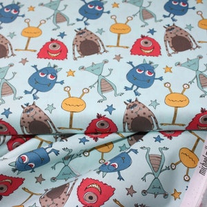 Peut inclure: Un tissu bleu clair avec un motif répété de monstres de dessin animé colorés. Les monstres sont dans différentes poses et ont des expressions faciales différentes. Il y a aussi de petites étoiles jaunes éparpillées sur tout le tissu.
