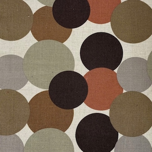 Könnte beinhalten: Ein Stoff mit einem sich wiederholenden Muster aus braunen, grauen und schwarzen Kreisen auf weißem Hintergrund.