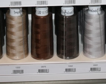 Può includere: Primo piano di dieci bobine di filo di vari colori, tra cui beige, marrone, grigio e verde. Le bobine sono etichettate con numeri e il marchio "Tre-Lock".
