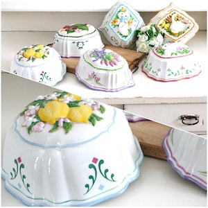 May include: Set of six white ceramic dessert moulds with various floral and animal designs. The moulds feature raised details and colourful painted accents.