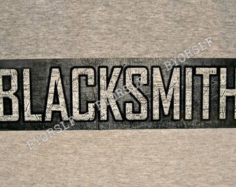 May include: Black metal sign with the word "BLACKSMITH" in white lettering. The sign has a distressed, textured look.