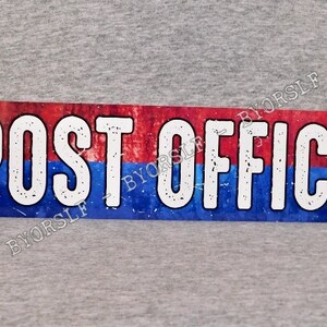 May include: A rectangular metal sign with the words "POST OFFICE" in large white block letters. The top half of the sign is red, and the bottom half is blue, with a distressed, vintage look.
