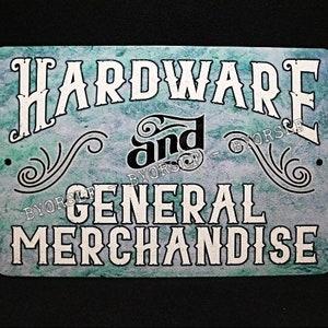 May include: A rectangular metal sign with rounded corners. The sign features the words "HARDWARE and GENERAL MERCHANDISE" in white, stylized lettering against a teal and blue mottled background. Decorative flourishes and small holes are present.
