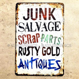 May include: A rectangular metal sign with a distressed, vintage appearance. The sign features the words "JUNK, SALVAGE, SCRAP PARTS, RUSTY GOLD, ANTIQUES" in various colors and fonts against a white background. The edges are rusty.