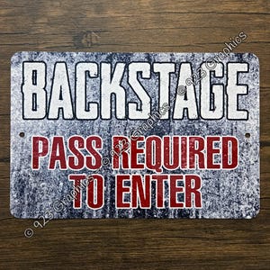 May include: A rectangular metal sign with a distressed dark blue and white textured background. The text BACKSTAGE is printed in large white letters, while the words PASS REQUIRED TO ENTER are printed in bold red letters below it.