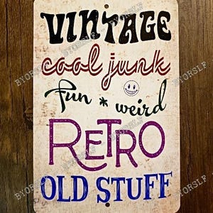 Puede incluir: Un letrero metálico rectangular con un fondo blanquecino desgastado. El letrero presenta las palabras "VINTAGE cool junk fun * weird RETRO OLD STUFF" en varios colores y fuentes, con una carita sonriente.