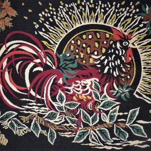 Peut inclure: Un tapis coloré avec un motif de coq. Le coq est rouge, noir et blanc et est entouré de feuilles vertes. Le fond est noir avec un soleil jaune.