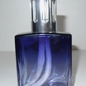 May include: A blue glass oil diffuser with a silver metal top and a white wick.