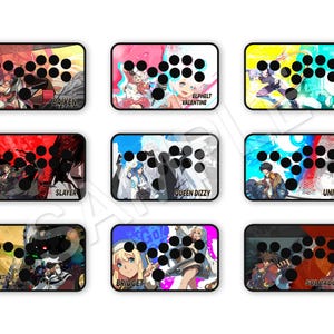 Peut inclure: Neuf sticks d'arcade personnalis&eacute;s avec divers designs de personnages. Chaque stick pr&eacute;sente une disposition de boutons noirs et un graphisme color&eacute;, avec des personnages comme Baiken, Elphelt Valentine et Slayer. Les sticks sont rectangulaires avec des coins arrondis.