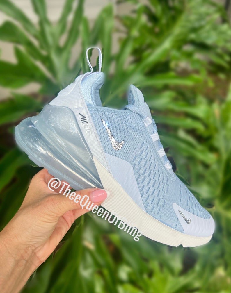Puede incluir: Zapatillas Nike Air Max 270 de color azul claro con un swoosh blanco y una suela de burbuja de aire transparente. El swoosh est&aacute; decorado con diamantes de imitaci&oacute;n transparentes.