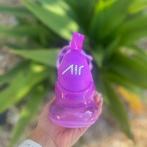 May include: Purple Nike Air Max 270 sneakers with a clear bubble sole and a rhinestone "AIR" logo on the back.