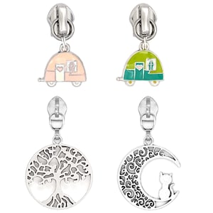 May include: Four silver zipper pulls with decorative charms. Two charms are colorful camper trailers, one pink and one green. The other two charms are a tree of life and a crescent moon with a cat silhouette.