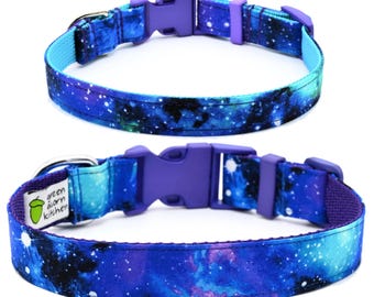 Puede incluir: Un collar para perro azul y morado con estampado de galaxia y una hebilla ajustable morada. El collar tiene el texto "green acorn kitchen" en el lateral.