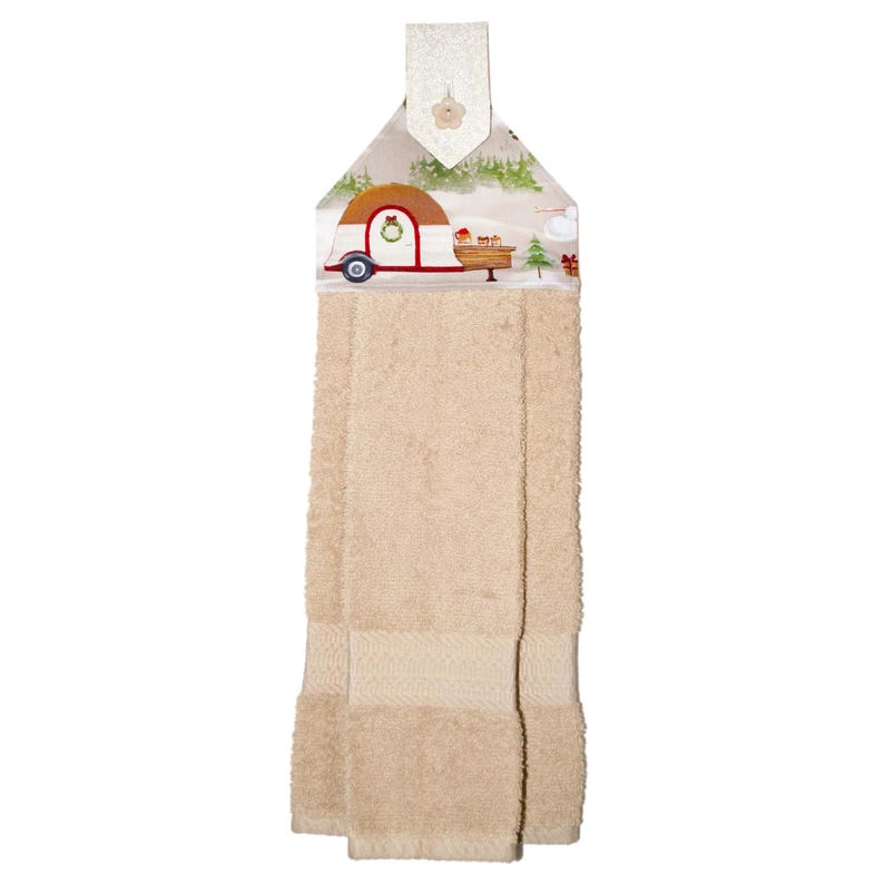 Puede incluir: Toalla de cocina beige con una parte superior decorativa con un dise&ntilde;o de caravana roja y marr&oacute;n, &aacute;rboles de Navidad y un paisaje nevado. La toalla tiene un lazo para colgar.