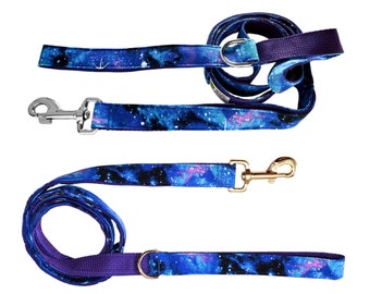 May include: Two blue and purple dog leashes with a galaxy print. One leash has a silver clip and the other has a gold clip.