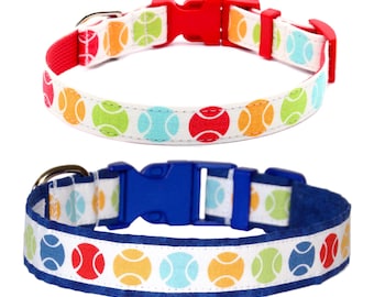 May include: Two dog collars with adjustable buckles. Both collars feature a white background with colorful tennis ball designs. One collar has a red buckle and the other has a blue buckle.