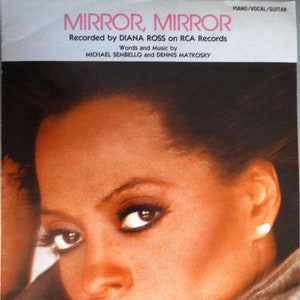 May include: A close-up of Diana Ross's face on the cover of a sheet music book for the song "Mirror, Mirror". The sheet music is for piano, vocal, and guitar. The text "Recorded by Diana Ross on RCA Records" is printed below the title.