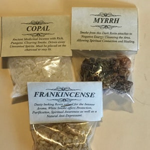 May include: Three small bags of incense, each with a label describing the type of incense. The bags are labeled "Copal", "Myrrh", and "Frankincense".