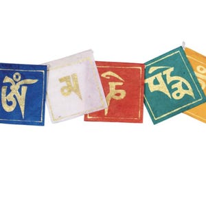 May include: A string of colorful prayer flags with gold symbols. The flags are square and in shades of blue, white, red, teal, and yellow. Each flag has a different symbol, and they are strung together with a white cord.