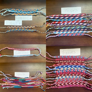 Puede incluir: Una colección de pulseras de amistad coloridas con diferentes patrones, incluyendo rayas, hojas, chevron, rollerball y espirales. Las pulseras están hechas con hilo de bordar y están atadas juntas con nudos.
