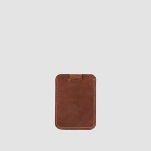 Cognac brown leather card holder for up to 8 cards, featuring a sleek pull-tab for easy access