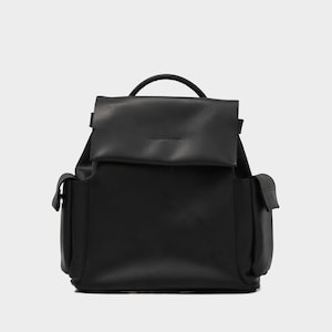 front view of European leather backpack in black with flap closure, top handle, and two side pockets, crafted from premium grain-textured leather