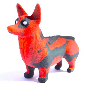 May include: A 3D printed figurine of a dog, painted in a red and black camouflage pattern. The dog is standing on all four legs and has a playful expression.