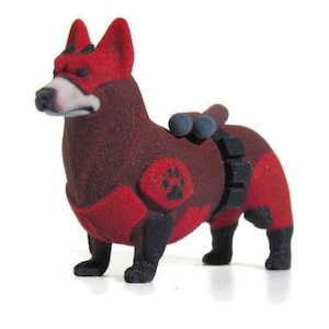 May include: A 3D printed figurine of a dog wearing a red and black superhero costume. The dog is standing on all fours and has a paw print on its chest.