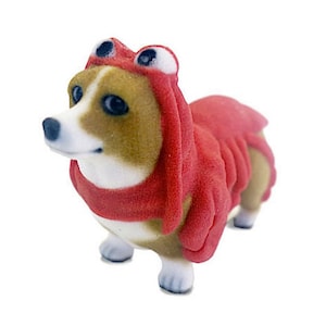 May include: A small, brown and white dog wearing a red lobster costume. The costume has a lobster claw design on the back and a lobster head with large, black eyes on the top.