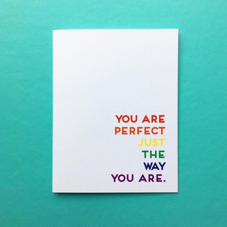 May include: A white card with the text "You are perfect just the way you are." in rainbow colors.