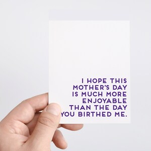 May include: A white card with purple text that reads "I hope this Mother's Day is much more enjoyable than the day you birthed me."