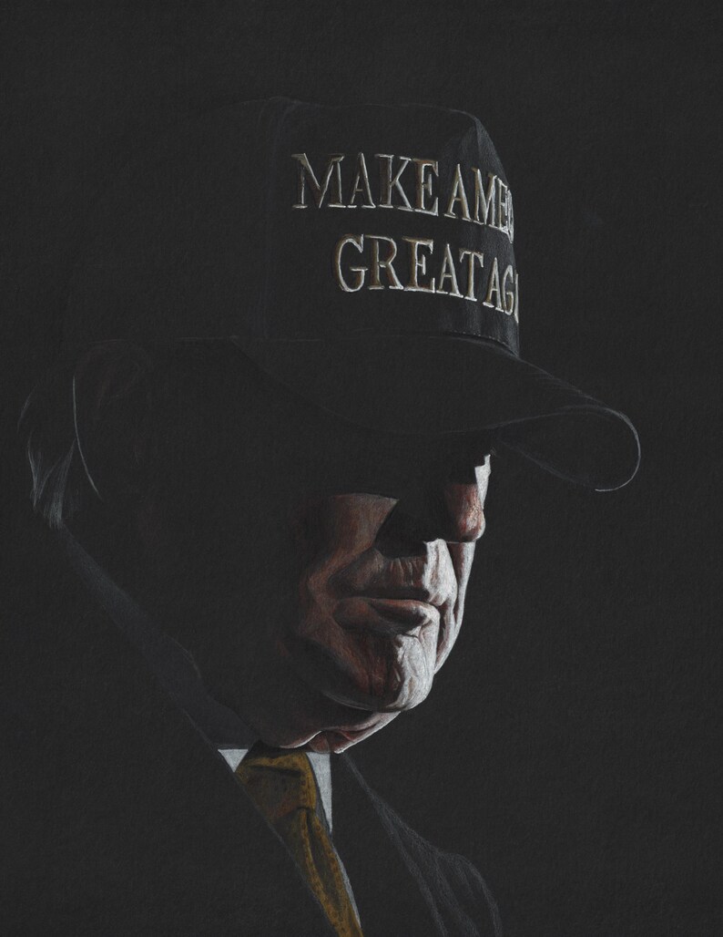 May include: A dark-toned portrait of a person wearing a black baseball cap with the text "MAKE AMERICA GREAT AGAIN" embroidered in white. The subject is dressed in a dark suit jacket with a visible yellow necktie, captured in low-key lighting.