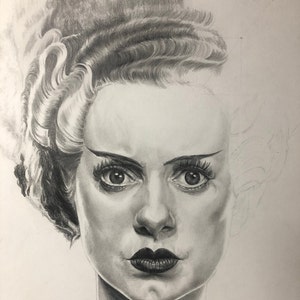Peut inclure: Un dessin au crayon graphite repr&eacute;sentant une personne avec une coiffure haute et volumineuse dot&eacute;e d'une m&egrave;che blanche. Le portrait pr&eacute;sente des ombres d&eacute;taill&eacute;es sur le visage, des l&egrave;vres sombres et des cils d&eacute;finis, le c&ocirc;t&eacute; droit &eacute;tant esquiss&eacute;.