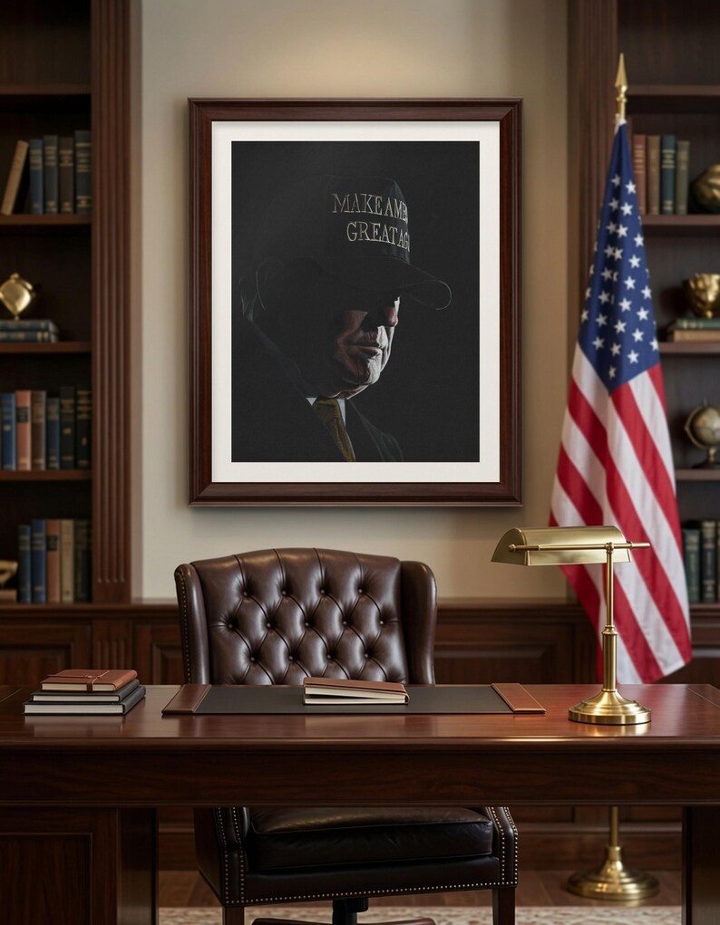 May include: A framed portrait of a person wearing a dark cap with the text MAKE AMERICA GREAT AGAIN, displayed in a study with a wooden desk, a leather chair, a brass lamp, bookshelves, and an American flag standing in the corner.