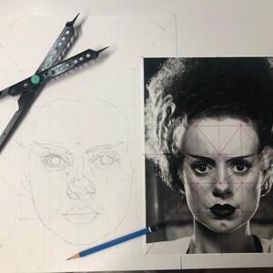 Peut inclure: Un portrait en noir et blanc de la fianc&eacute;e de Frankenstein avec des lignes de grille g&eacute;om&eacute;triques superpos&eacute;es, accompagn&eacute; d'un croquis au crayon du m&ecirc;me visage &agrave; gauche, d'un compas noir et d'un crayon bleu sur la surface.