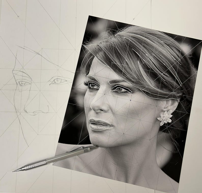 May include: A black and white portrait drawing of a person with a floral earring, featuring geometric construction lines overlaid on the face. A silver mechanical pencil rests on the bottom left corner of the paper.