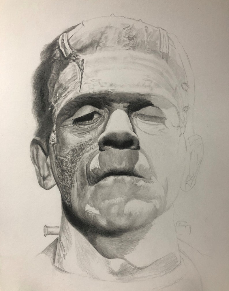 Peut inclure: Un dessin au crayon graphite repr&eacute;sentant une cr&eacute;ature &agrave; la t&ecirc;te plate, aux paupi&egrave;res lourdes et au front pro&eacute;minent. Le visage pr&eacute;sente des ombrages d&eacute;taill&eacute;s, une cicatrice cousue sur le front et un boulon m&eacute;tallique sur le cou.