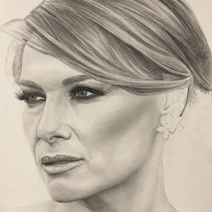 May include: A graphite pencil drawing of a person with short, layered hair, styled with a side part. The subject has defined eyebrows, long eyelashes, and a floral-shaped earring on the visible ear, rendered in shades of gray and white.