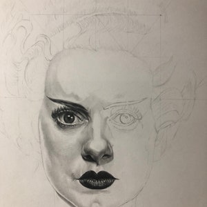 Peut inclure: Un dessin au crayon graphite d'un visage en cours de r&eacute;alisation. Le c&ocirc;t&eacute; droit pr&eacute;sente un &oelig;il tr&egrave;s d&eacute;taill&eacute; avec eye-liner, cils et peau ombr&eacute;e, tandis que le c&ocirc;t&eacute; gauche reste un contour l&eacute;ger. Les l&egrave;vres sombres sont ombr&eacute;es.