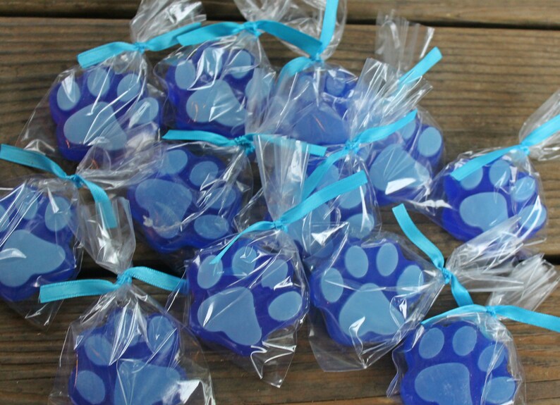 K&ouml;nnte beinhalten: Blaue Pfotenabdruck-Seifen, verpackt in durchsichtigen Cellophanbeuteln mit blauen Schleifen.