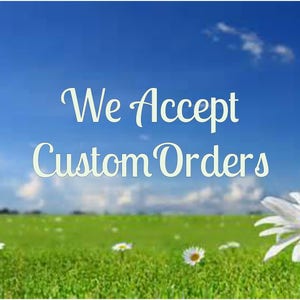 May include: A green grassy field with white daisies and a blue sky with white clouds. The text "We Accept Custom Orders" is written in white cursive font.