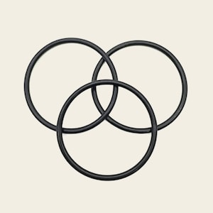 May include: Three smooth, matte black circular rings are interlocked in a triangular formation. Each ring has a consistent, thin, rounded profile. The rings are positioned to overlap, creating a central triangular space where the three circles meet.