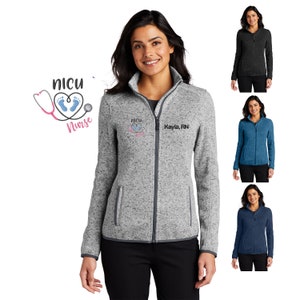 May include: A heather grey fleece jacket with a zipper closure. The jacket has a small embroidered design on the left chest that says "NICU Nurse" with a stethoscope and footprints. The right chest has the text "NICU Nurse Kayla, RN".